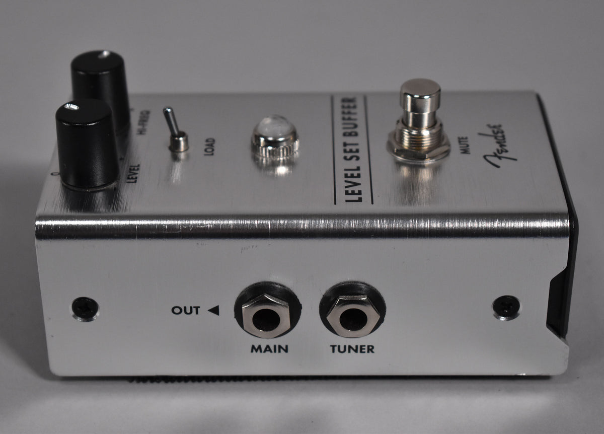 A brushed silver pedal, angled to show the top with two black knobs, a toggle switch, an LED, a footswitch, and two output jacks.