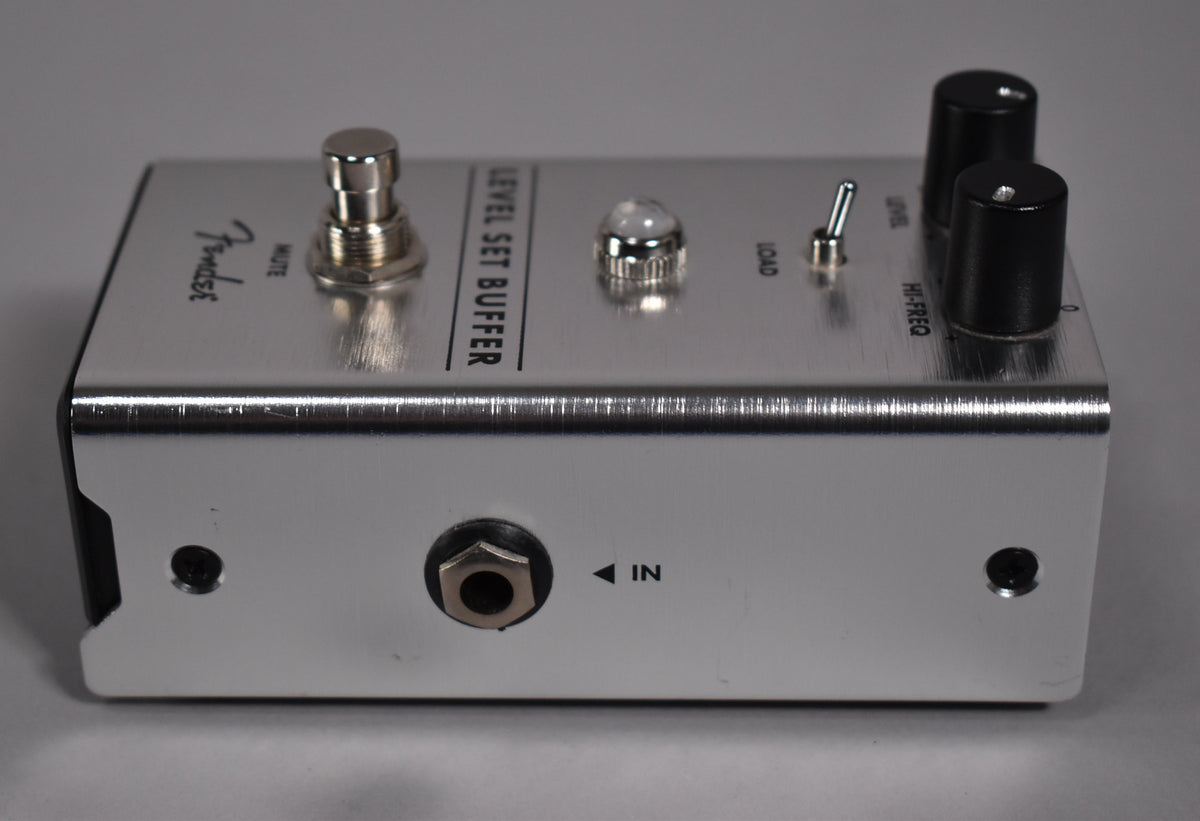 Brushed silver pedal, angled from the front right, showing the footswitch, toggle switch, two black knobs, and the side input jack.