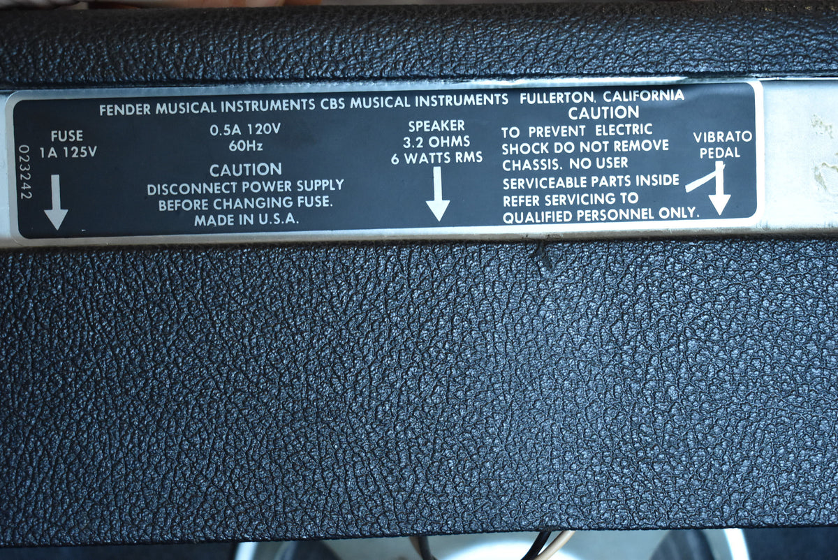 Close-up of the amp's rear panel, showing the black textured tolex and the silver-colored metal plate with white text.