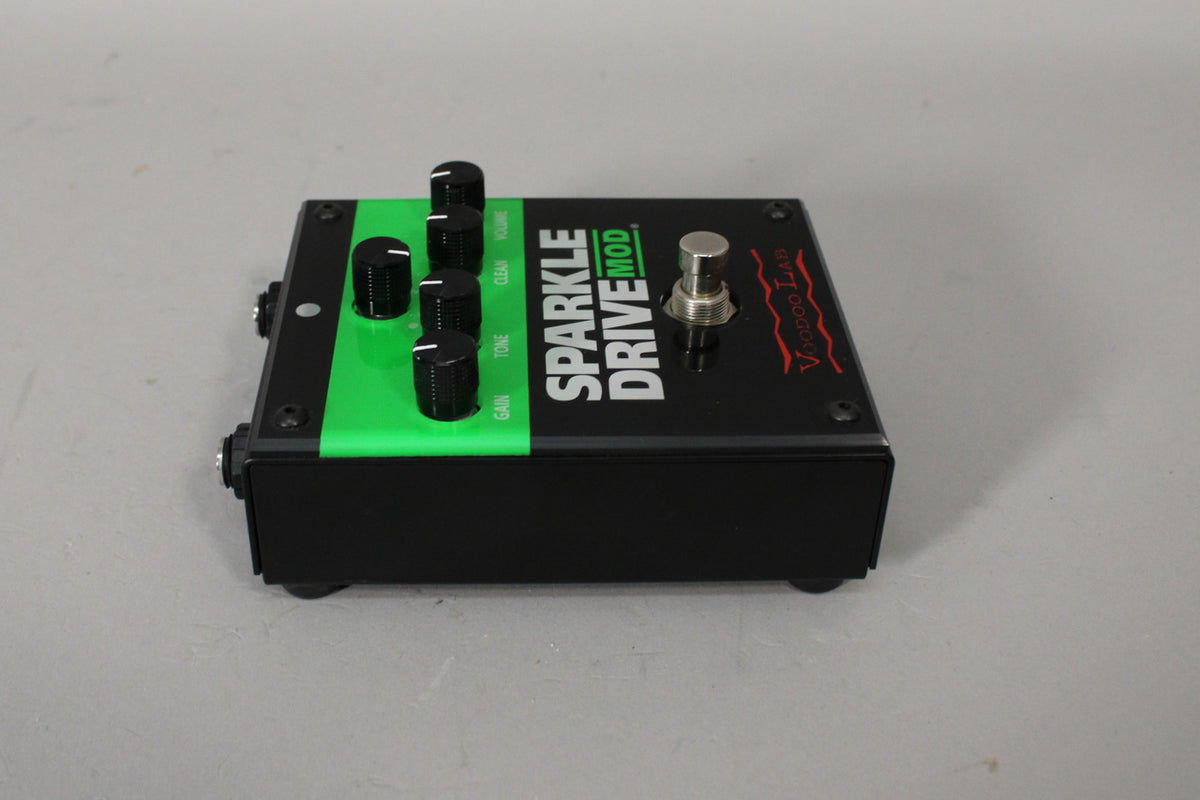 A black pedal with a bright green stripe on the left, four black control knobs, and a silver footswitch.