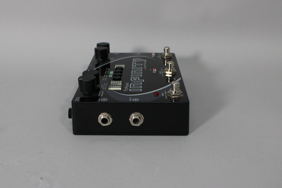 A black stereo looper pedal, angled from the right, showing two input jacks on the front and three footswitches on top.