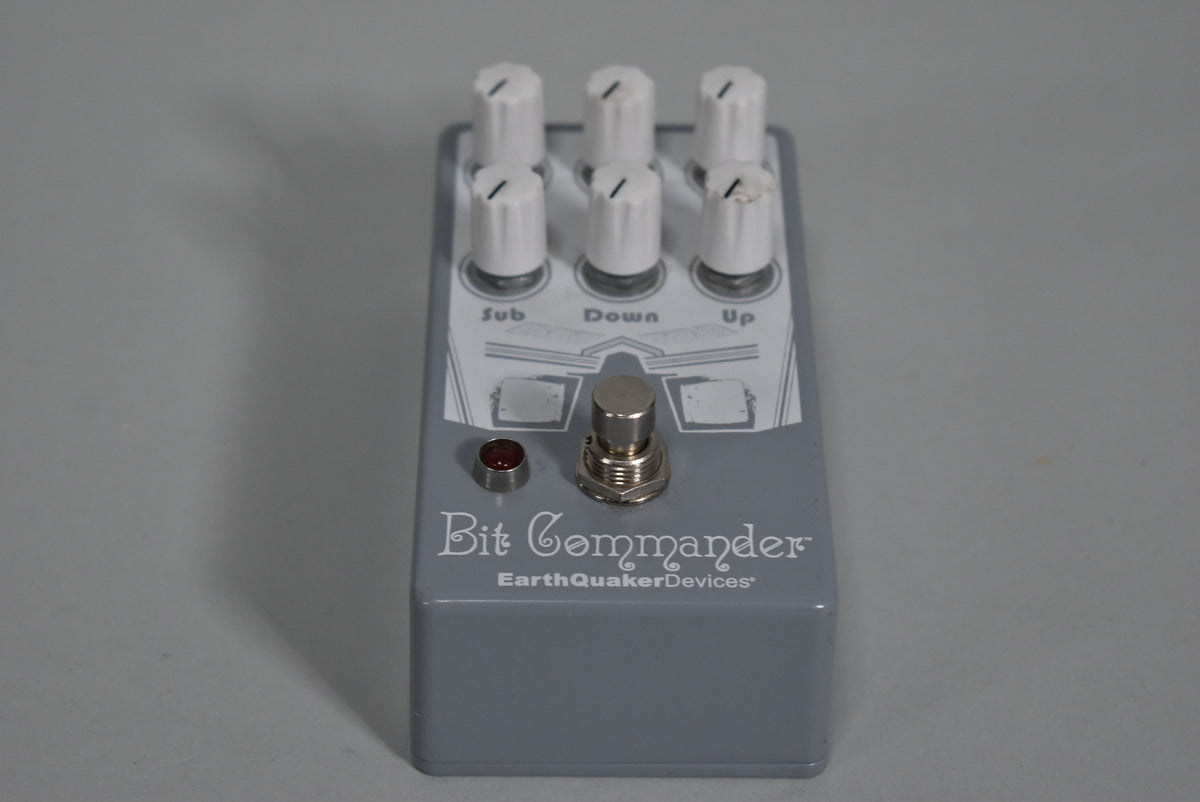 A light grey pedal with six white knobs, a silver footswitch, and a red indicator light, viewed from a slight angle.