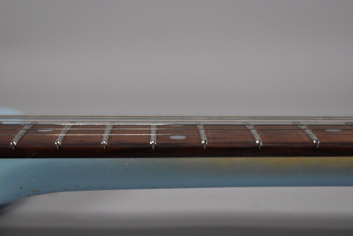 Close-up of the Sonic Blue guitar neck, showing the dark fretboard with dot inlays and light fret wear on the lower frets.