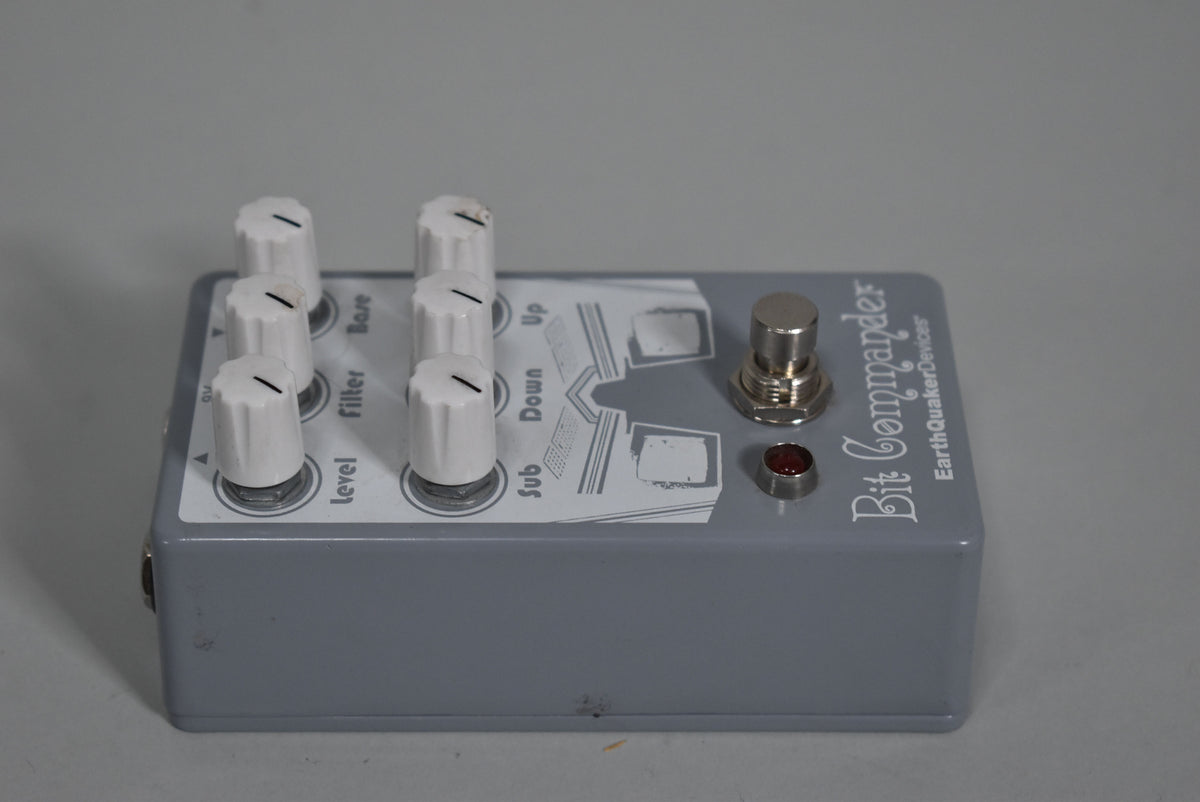 A gray pedal with a white faceplate, six white knobs, a silver footswitch, and a red indicator light, viewed from the right.