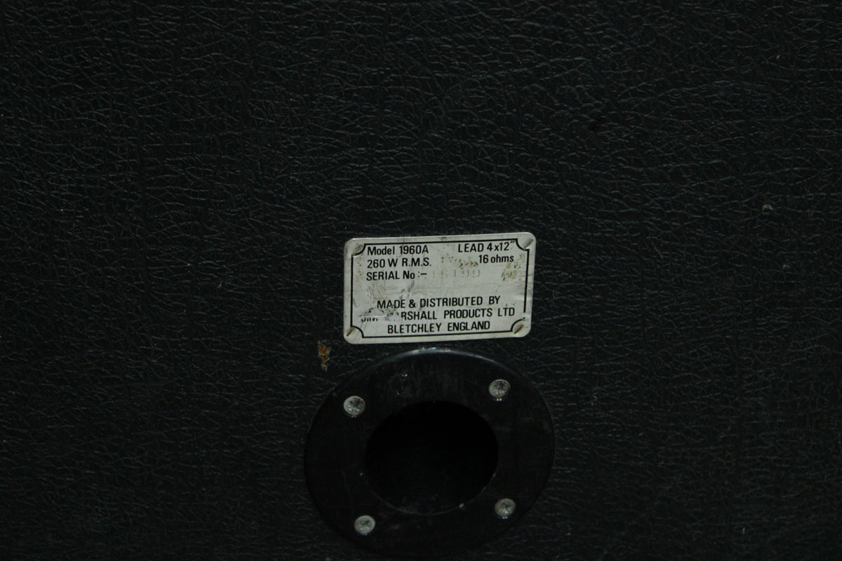 Close-up of the black textured back panel, showing the input jack and a worn white label with specifications.