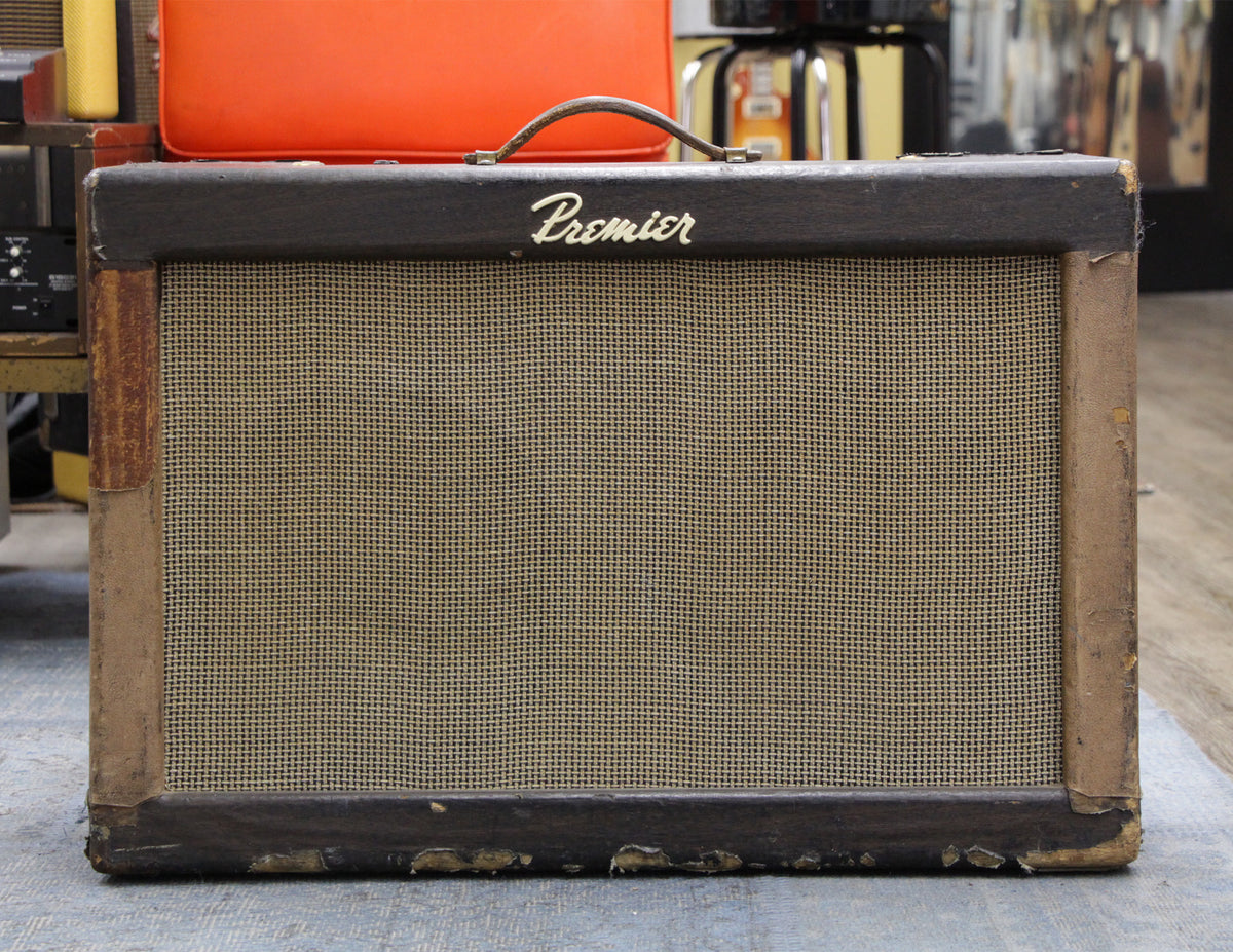 Front view of a dark brown combo amp with a tan grille cloth, showing heavy wear and peeling on the edges.