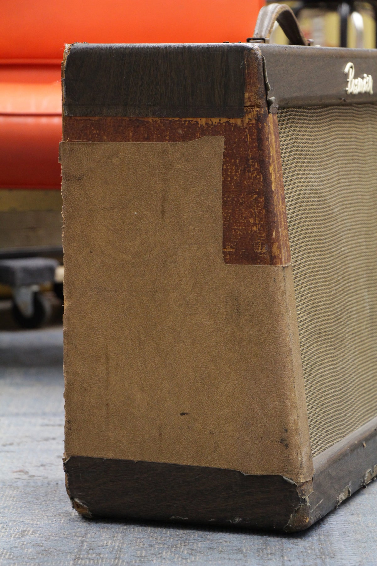 The amp's left side shows heavily worn brown tolex with a large tan patch, revealing lighter wood underneath.
