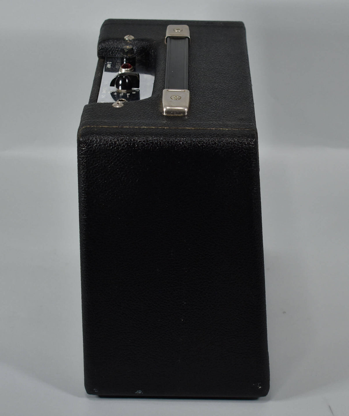 Side view of the black textured amp, showing the silver control panel with a red jewel light and black knobs, plus a top handle.