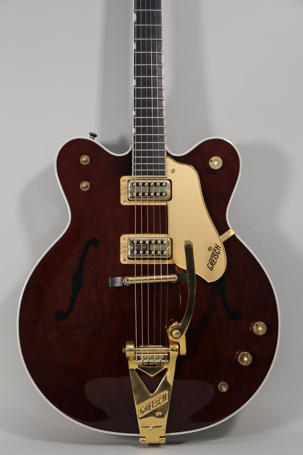Dark cherry hollow body guitar with gold hardware, f-holes, and a Bigsby vibrato, viewed from the front.