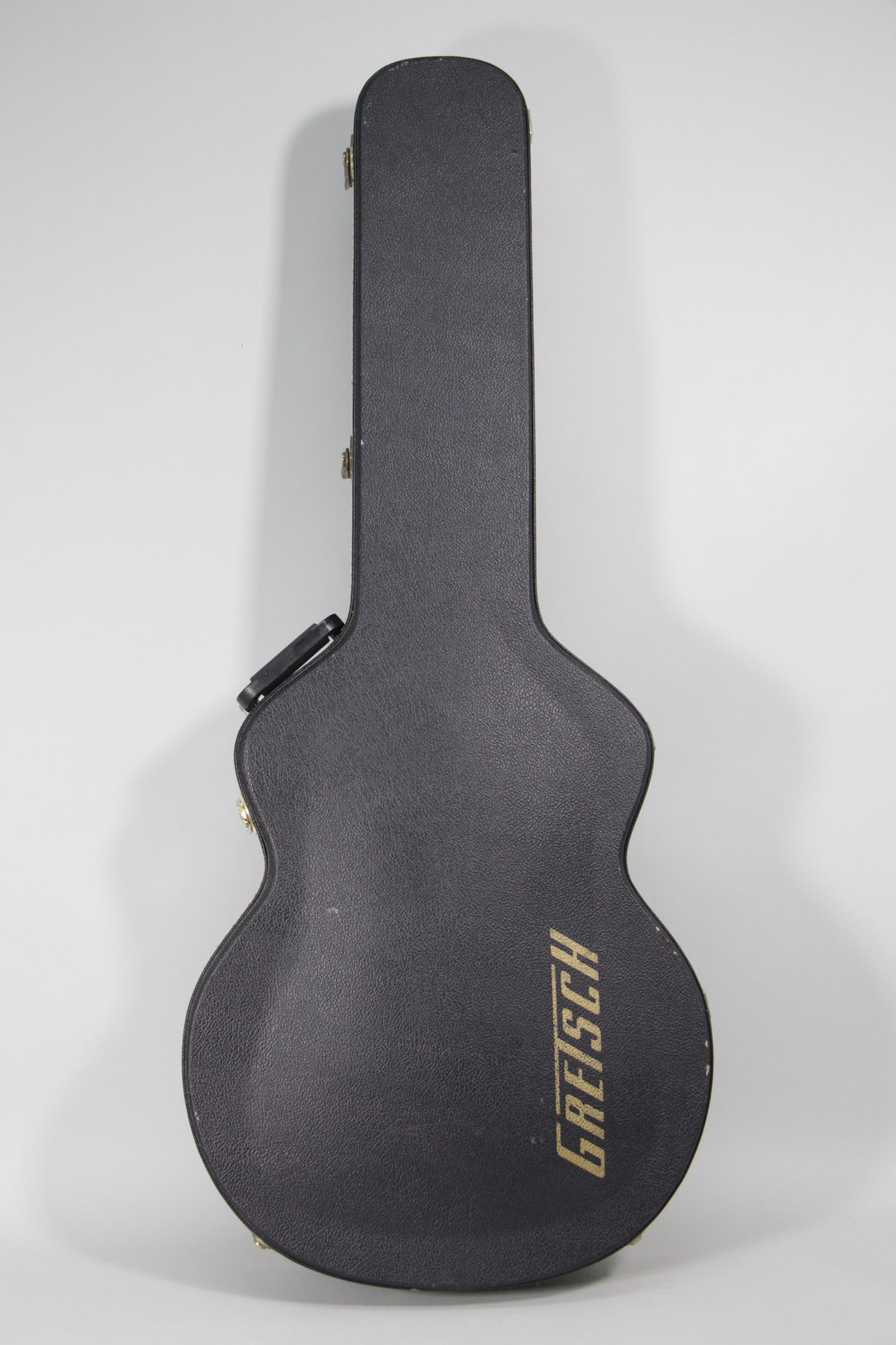 Black textured hard case for a hollow body guitar, with gold latches and "GRETSCH" in gold lettering on the lower bout.