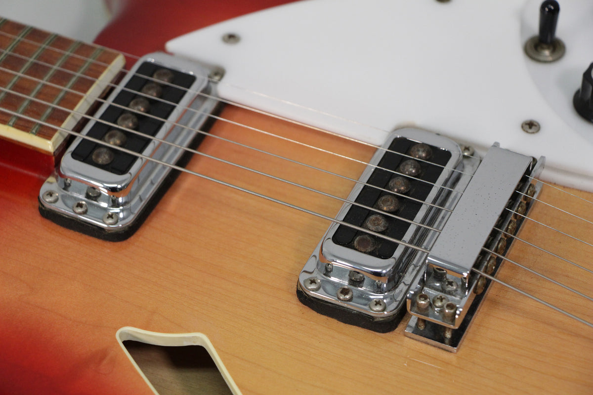 Close-up of the Fireglo body, showing the neck and bridge pickups, white pickguard, and a f-hole.