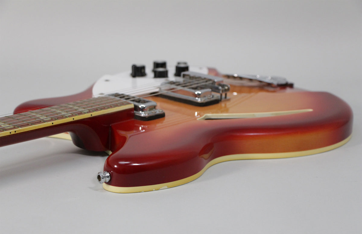 The Fireglo semi-hollow guitar body, with its f-hole and chrome hardware, is viewed from the lower bout, showing some finish wear.