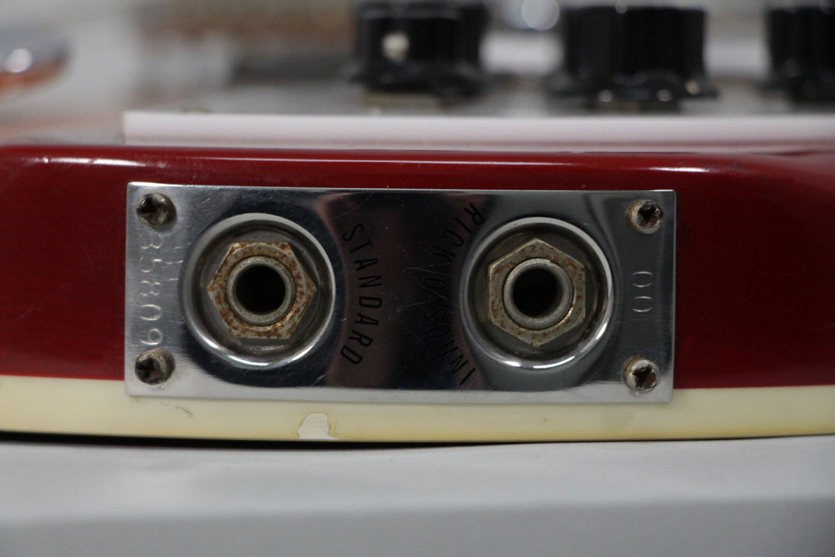 Close-up of the guitar's Fireglo finish body, showing the chrome output jack plate with two rusty jacks and visible wear on the screws.