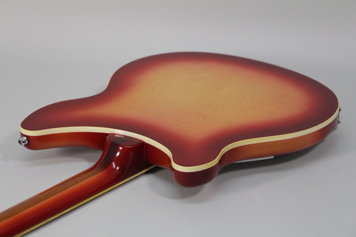 The Fireglo guitar's back, showing the red-to-amber sunburst finish, cream binding, and the neck joint with a visible strap button.