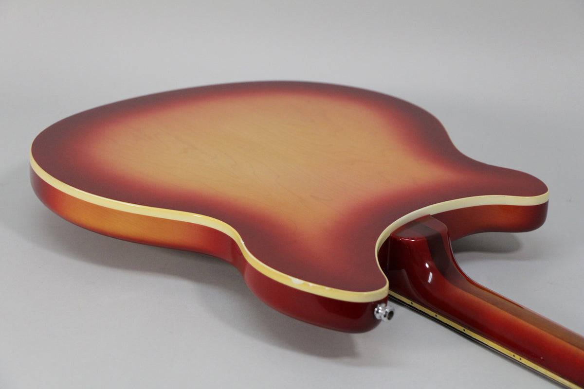 The guitar's Fireglo back and neck are shown from the lower bout, with cream binding and a chrome output jack.