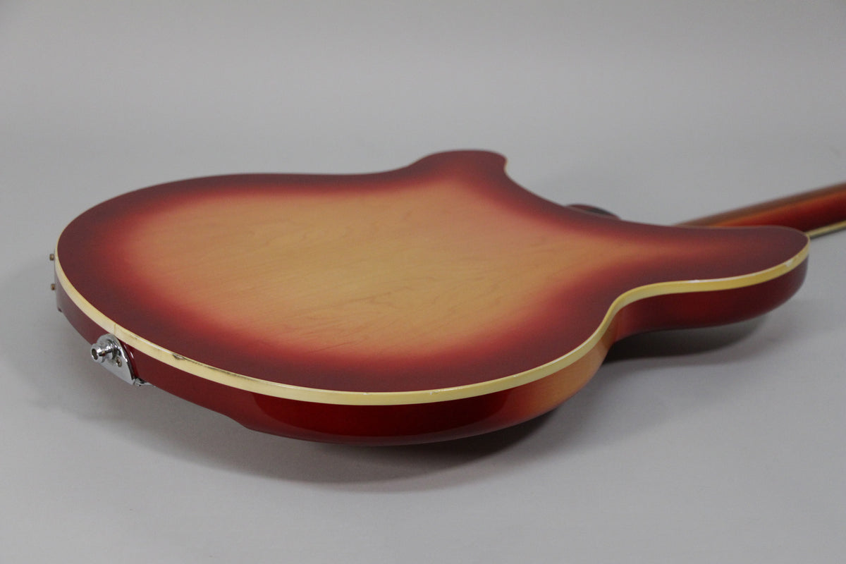 The guitar's Fireglo back, with a light center fading to dark red, shows a chrome output jack and some light wear on the binding.