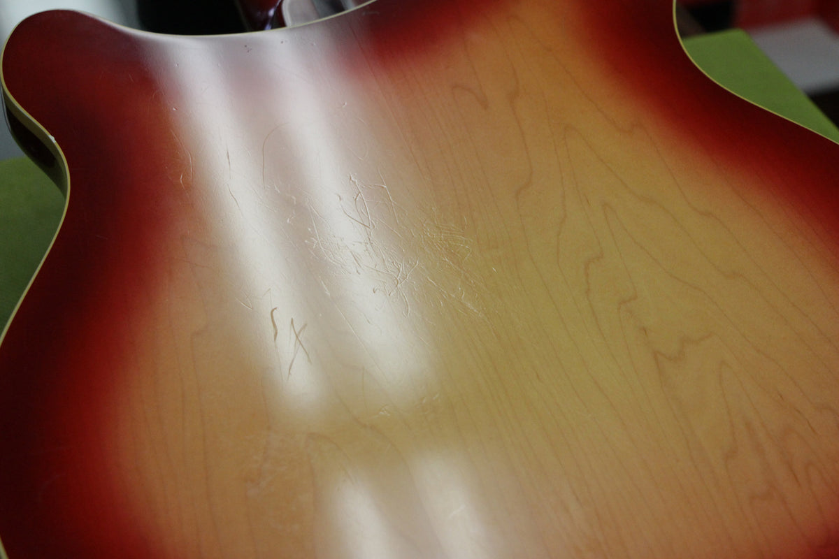 Close-up of the guitar's Fireglo back, showing heavy buckle rash and finish checking across the central light-colored area.