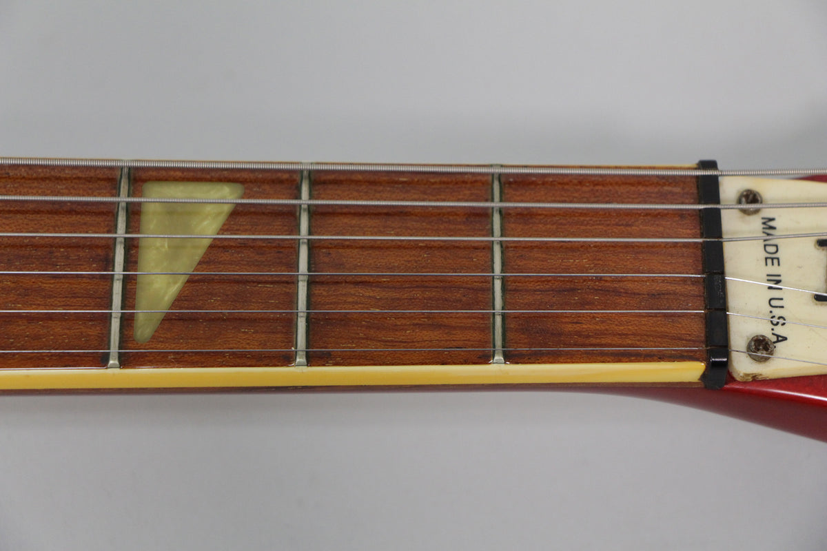 Close-up of the fretboard, showing a light-colored triangular inlay at the 5th fret, a black nut, and "MADE IN U.S.A." on the headstock.