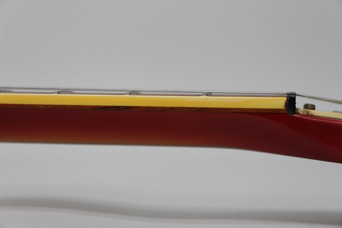 Close-up of the Fireglo neck, showing the binding, frets, and nut, with some wear visible on the binding and nut.