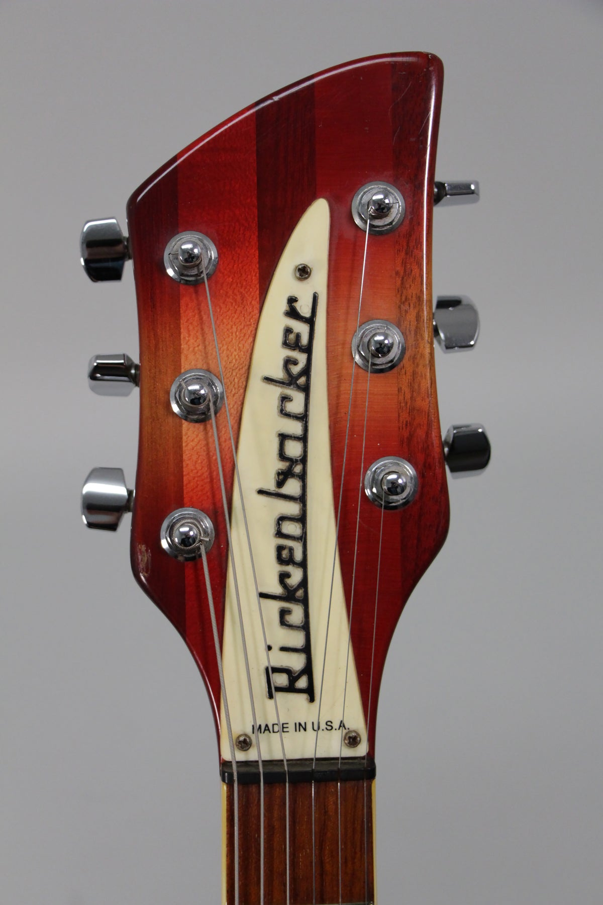 Close-up of the Fireglo headstock, showing six chrome tuners, a cream-colored truss rod cover, and a dark rosewood fretboard.