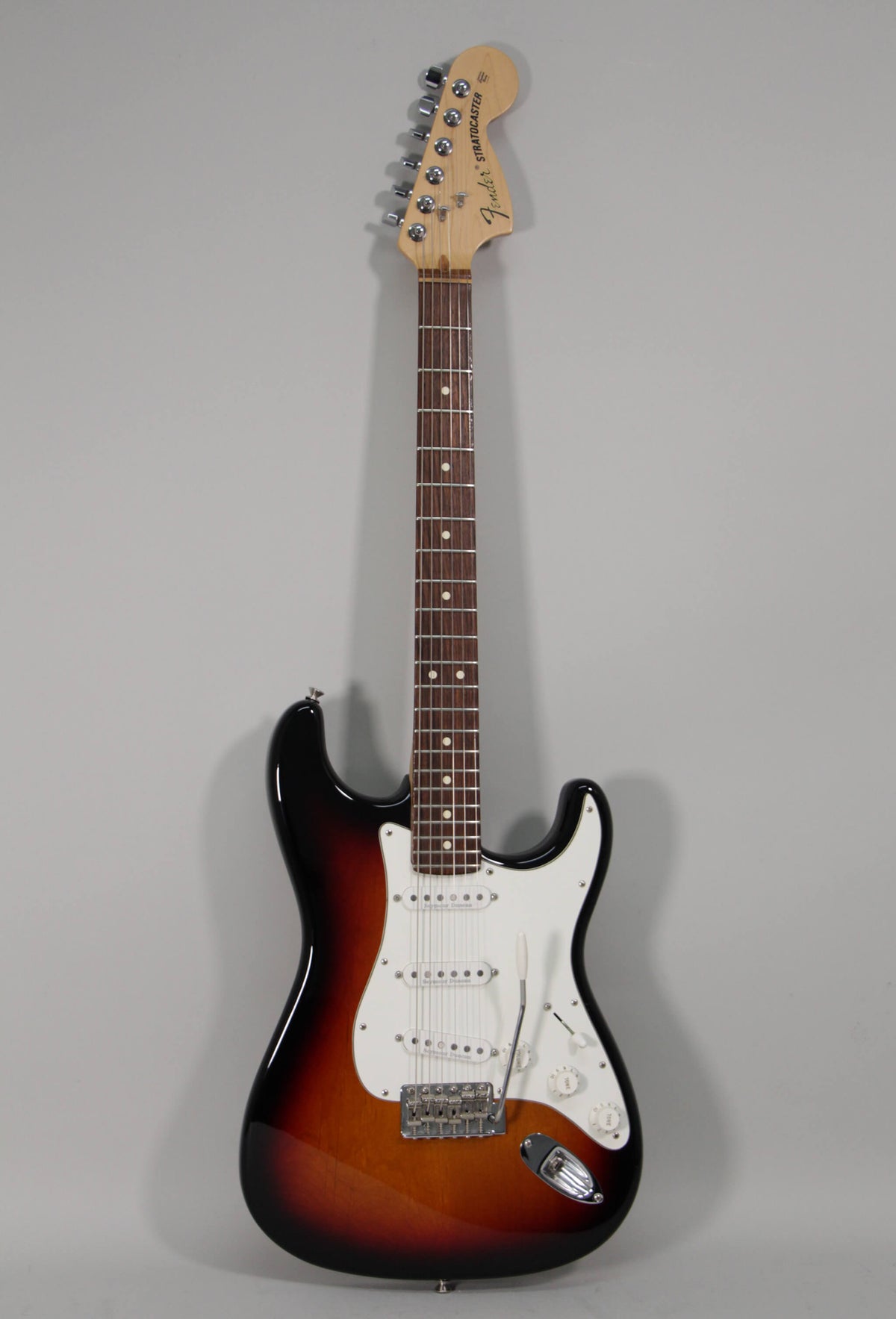 Full-length view of a sunburst Stratocaster with a white pickguard, three single-coil pickups, and a tremolo bridge.