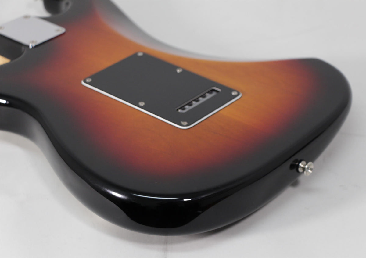 The guitar's sunburst back shows a black tremolo cover and a chrome output jack on the lower bout.