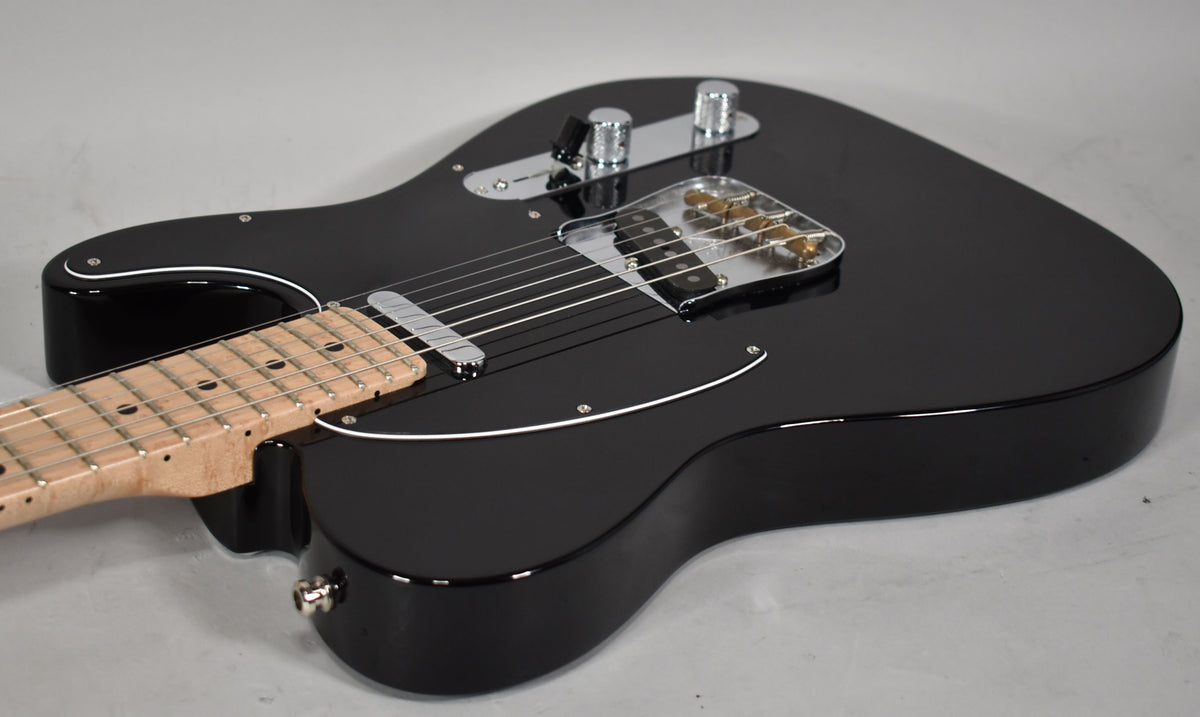 The black Telecaster body, with a white binding and chrome hardware, is angled from the lower bout towards the headstock.