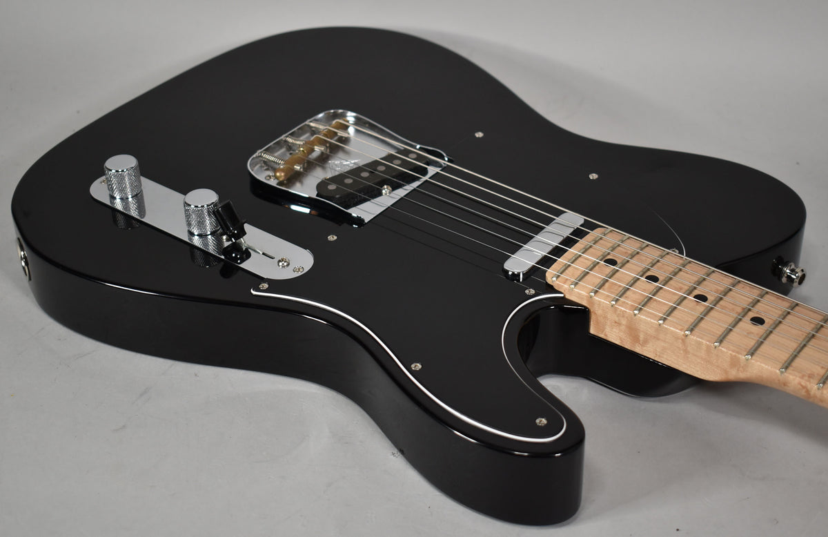 A black Telecaster body with a glossy finish, white pickguard trim, chrome hardware, and a light maple neck.