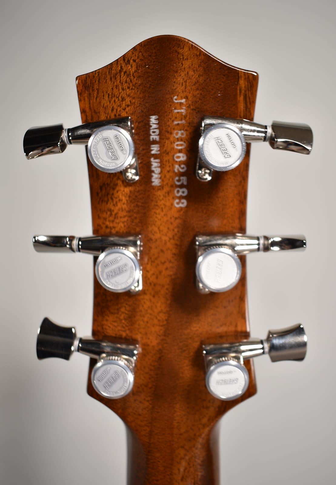 Rear view of the mahogany headstock with a serial number, "MADE IN JAPAN" text, and six chrome tuning machines.