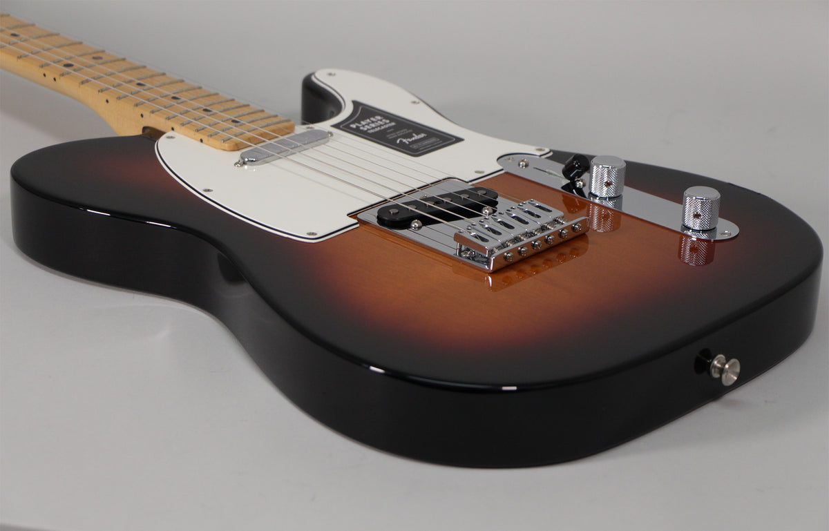The Telecaster's glossy sunburst body is angled from the lower right, revealing the chrome bridge, control plate, and white pickguard.