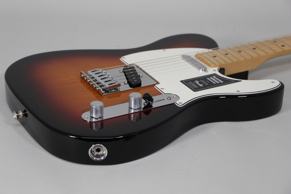 The Telecaster's glossy sunburst body is angled from the lower bout, showing the chrome bridge, control plate with two knurled knobs, and white pickguard.
