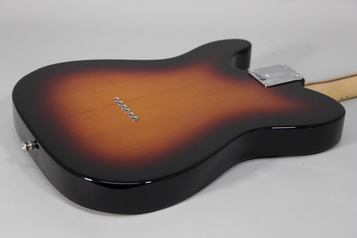 The guitar's back, in a glossy sunburst finish, shows six string-through-body ferrules and a chrome neck plate.