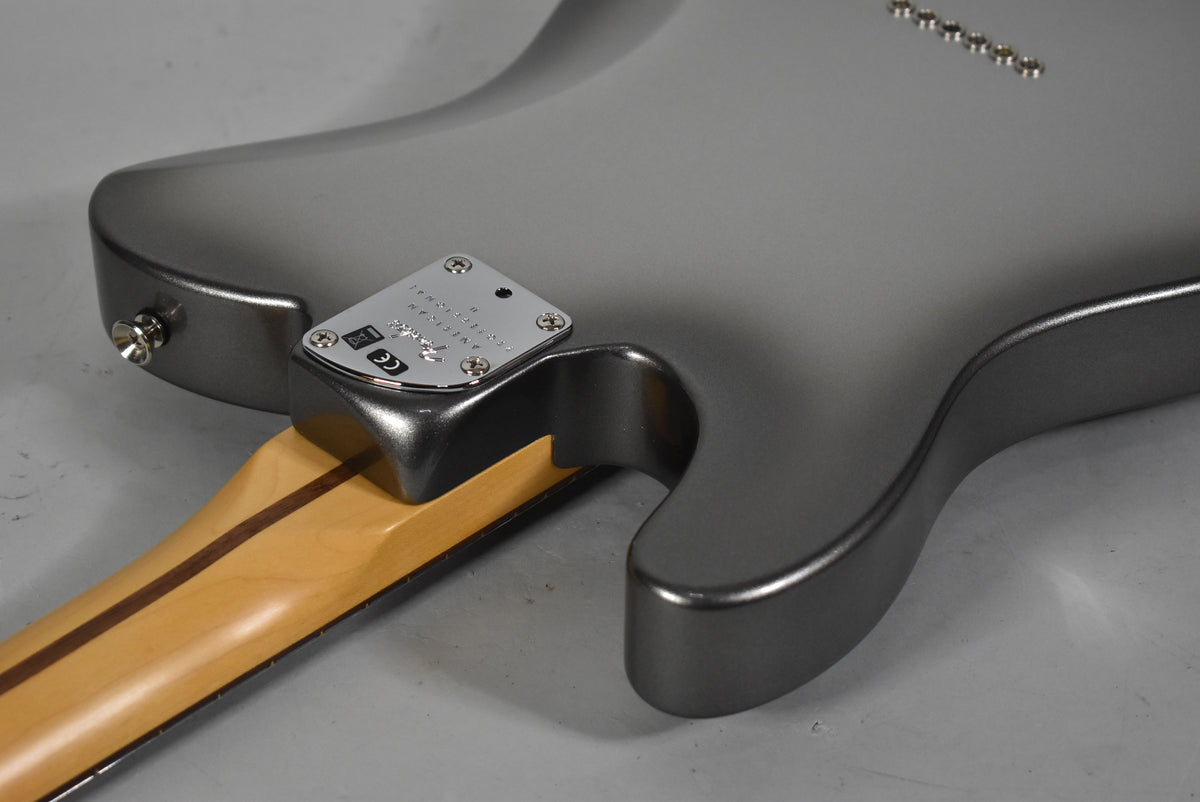 The back of a metallic gray guitar body, showing the neck joint, chrome neck plate, and output jack.