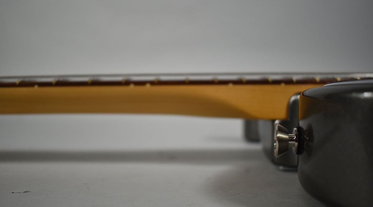 The Telecaster's Mercury finish body and neck are viewed from the side, with a chrome strap button visible on the lower bout.