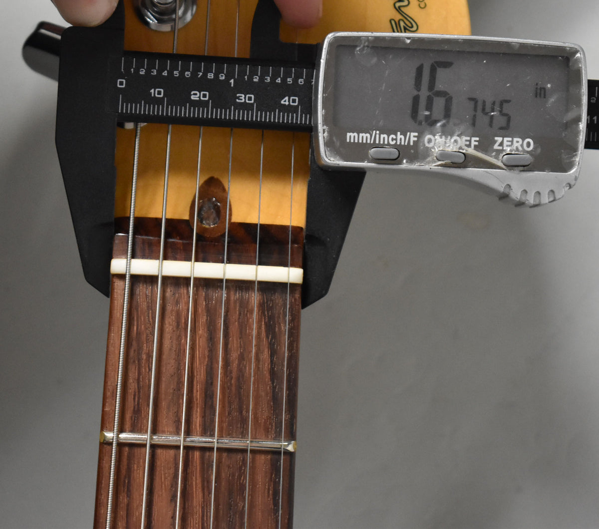 Close-up of the guitar's nut and first fret, with digital calipers measuring the nut width at 1.745 inches.