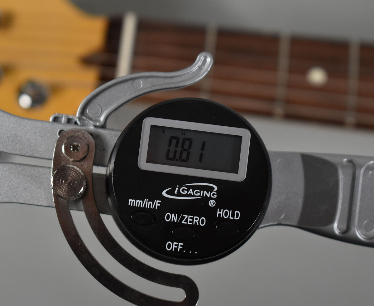 A close-up of a digital caliper measuring the fret height at 0.81mm on the Telecaster's rosewood fretboard.