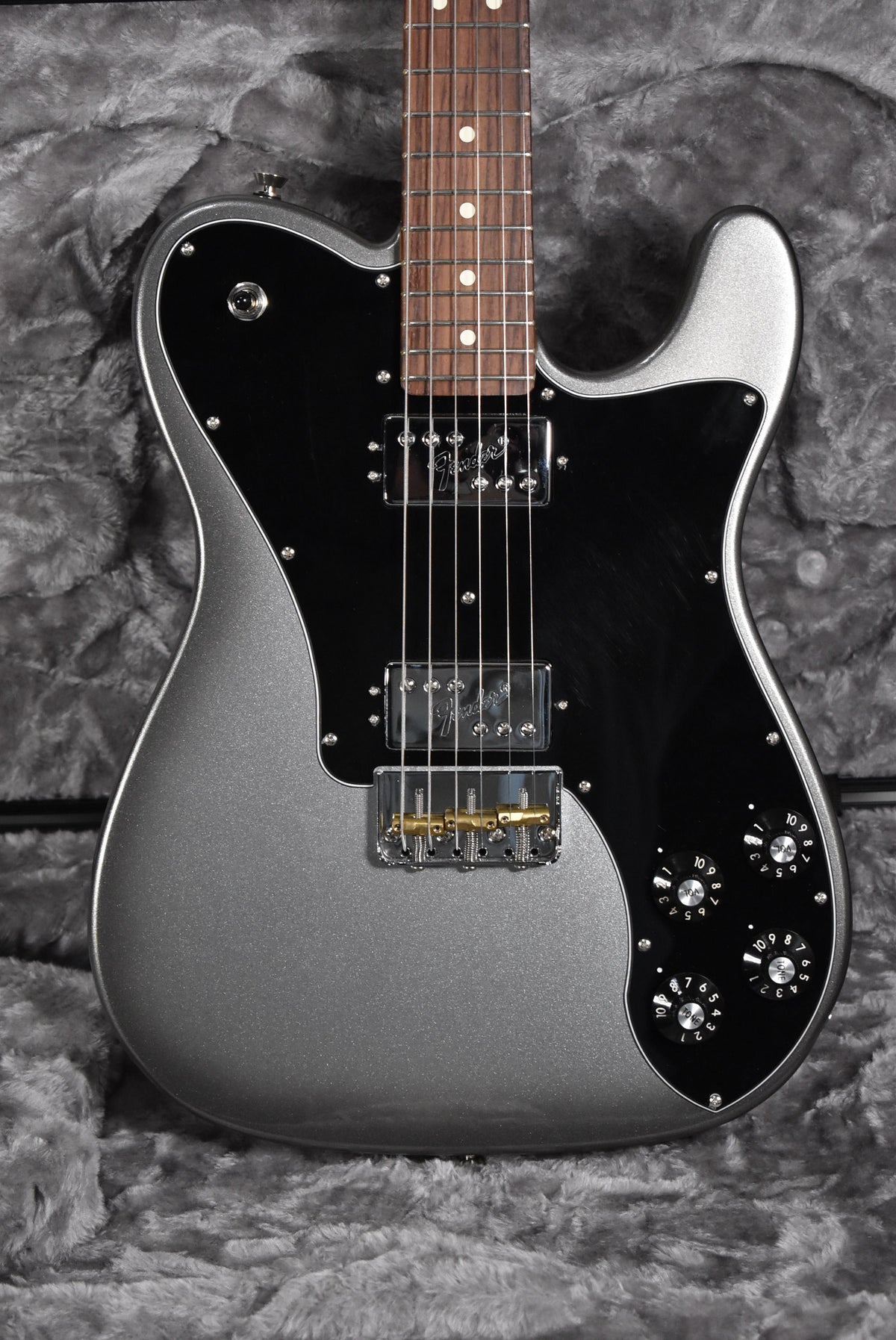 Full-frame, top-down view of a metallic silver Telecaster with a black pickguard, two humbuckers, and four black control knobs.
