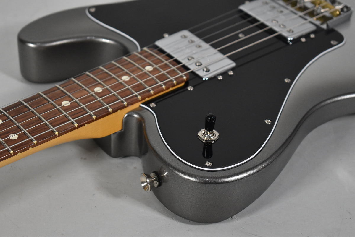 Close-up of the metallic gray guitar body and dark rosewood fretboard, showing the black pickguard, two humbuckers, and a 3-way switch.