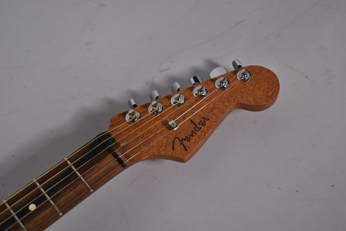 Close-up of the guitar's headstock and upper fretboard, showing the natural wood finish, six chrome tuners, and light-colored strings.