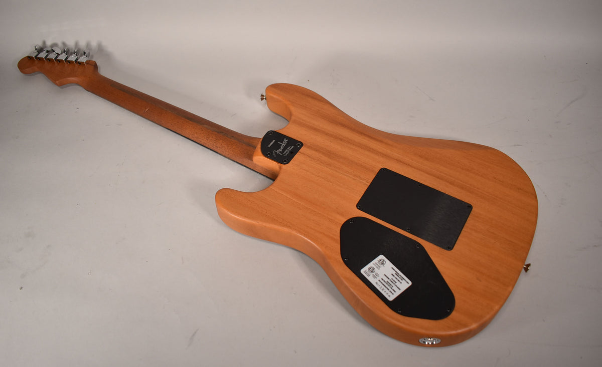 The guitar's back, in natural wood finish, shows two black control cavity covers and a light brown neck with chrome tuners.