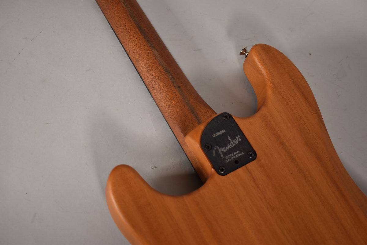 The guitar's back, in a light wood finish, shows the neck joint with a black rectangular plate and a chrome strap button.