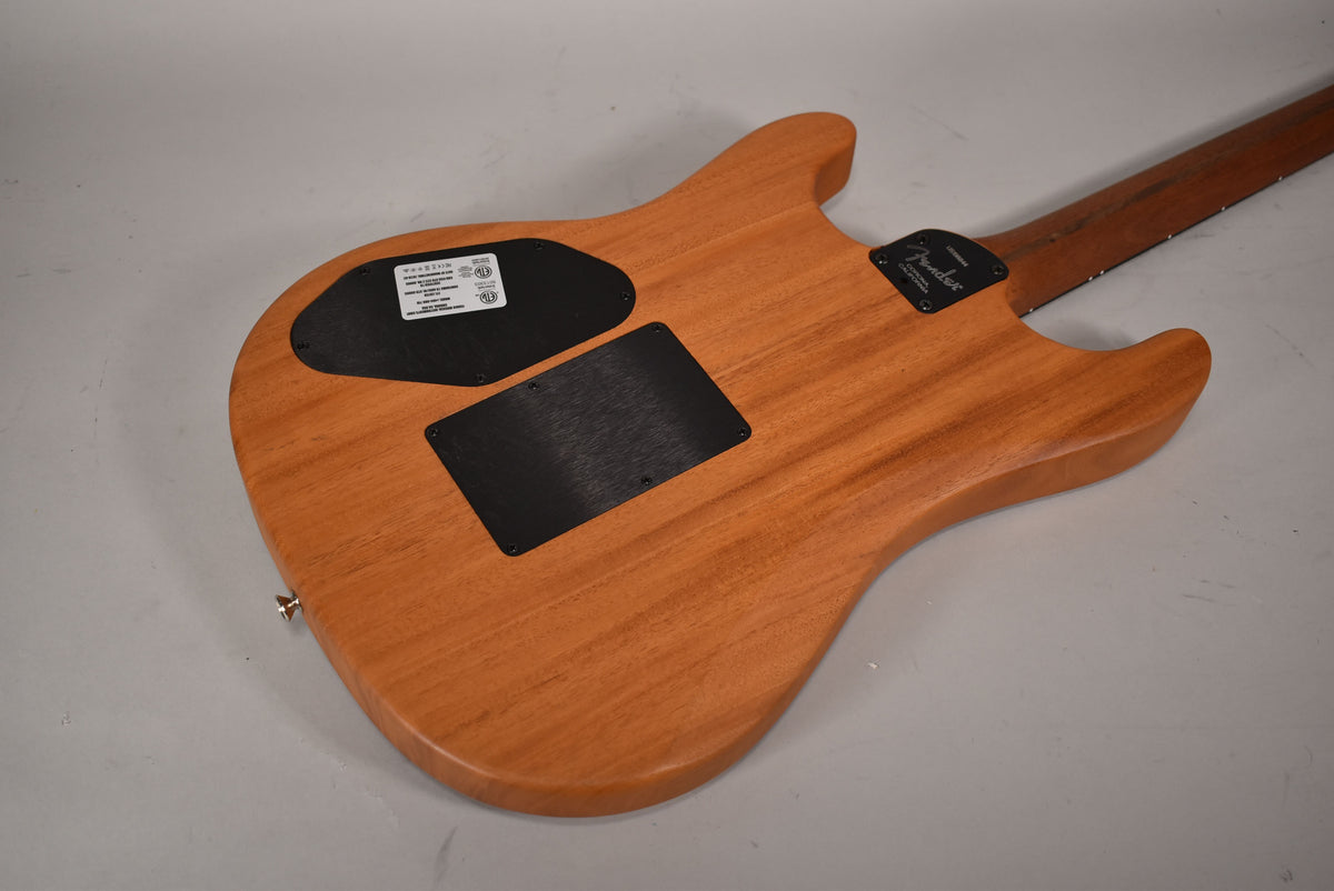 The guitar's back, in natural wood finish, shows two black control cavity covers and a chrome strap button.