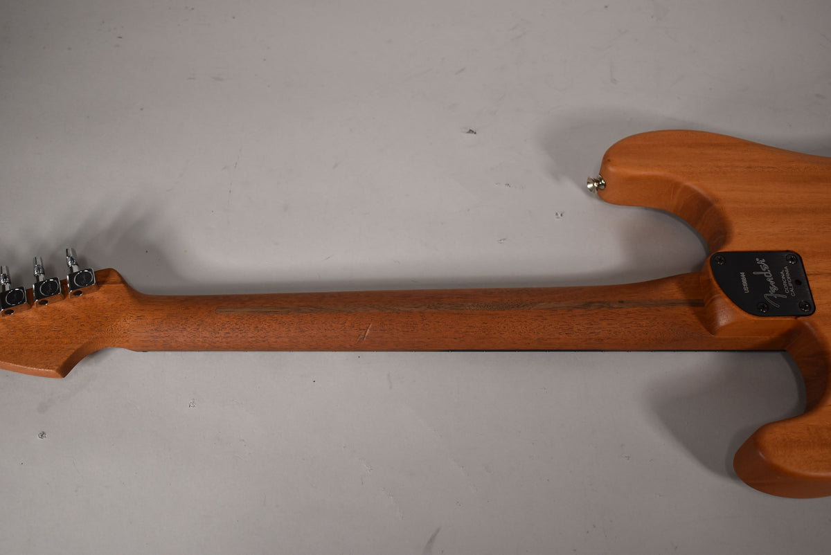Back of the guitar, showing the natural wood neck and body, with a black neck plate and chrome tuners on the headstock.
