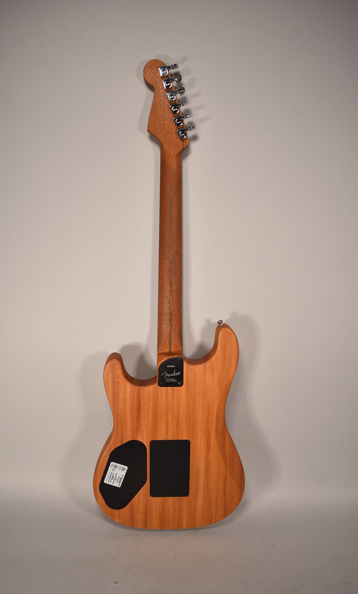Full back view of a light brown guitar with a natural wood finish, showing the headstock, neck, and body.