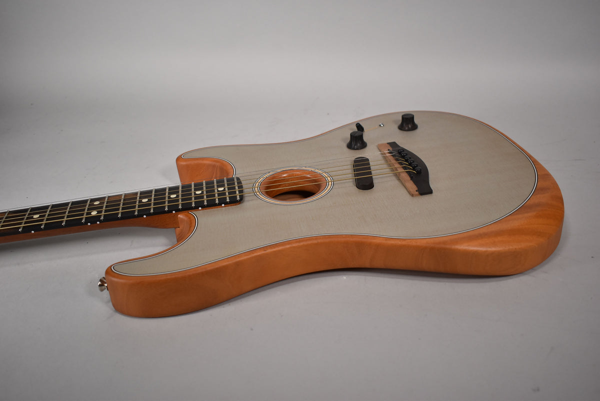 The sonic blue Acoustasonic Stratocaster is angled from the left, showing its light blue top, natural wood sides, and black bridge and controls.