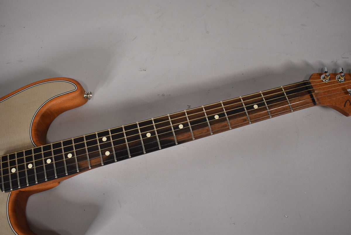 Close-up of a guitar neck and part of the body, showing a dark fretboard with white dot inlays and a light wood body.