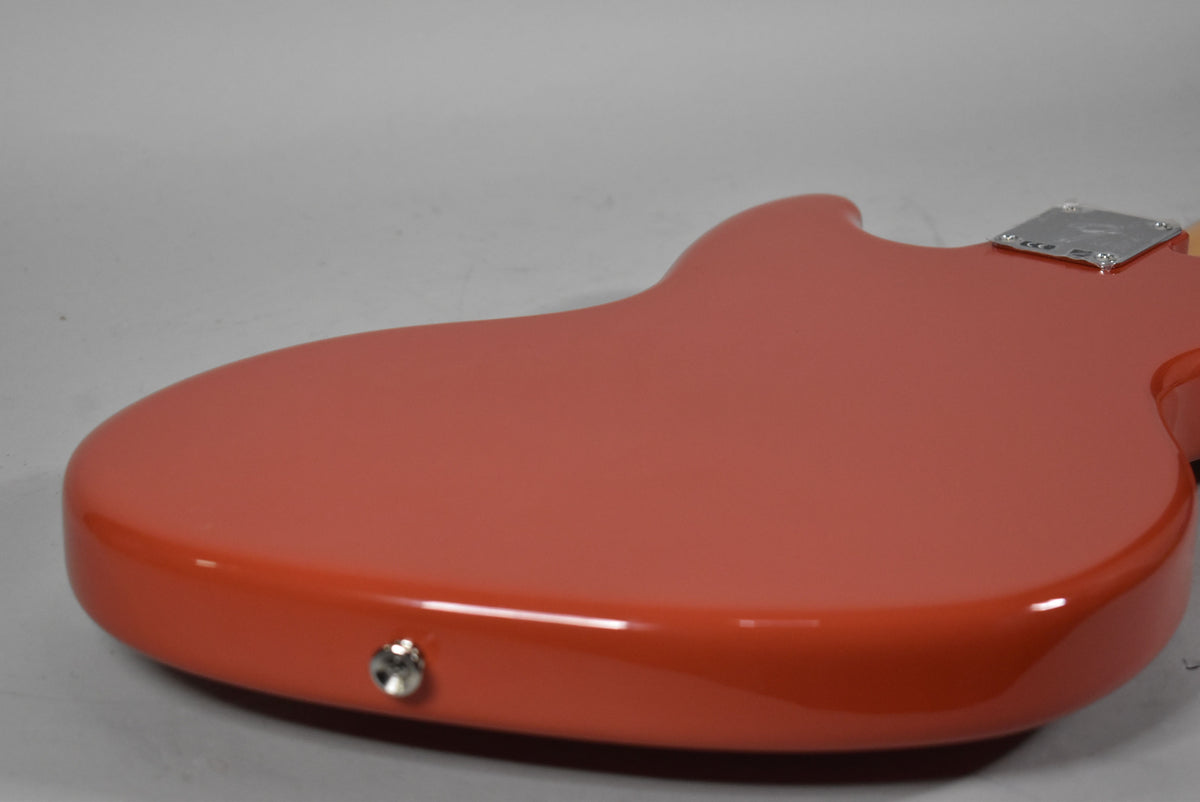 The guitar's Dakota Red body, seen from the back, shows a chrome neck plate and a chrome output jack on the lower bout.