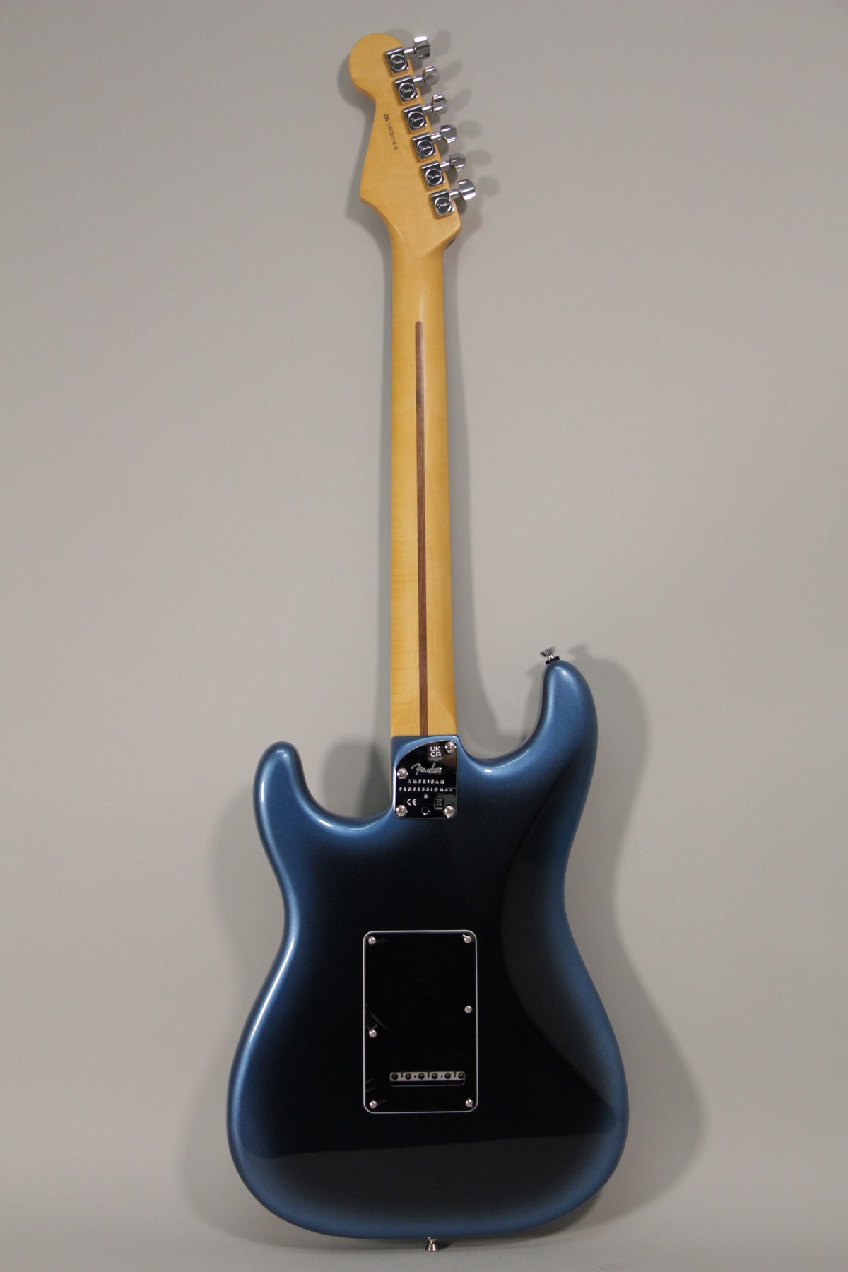 Full rear view of a dark blue metallic Stratocaster with a light maple neck and chrome tuners.