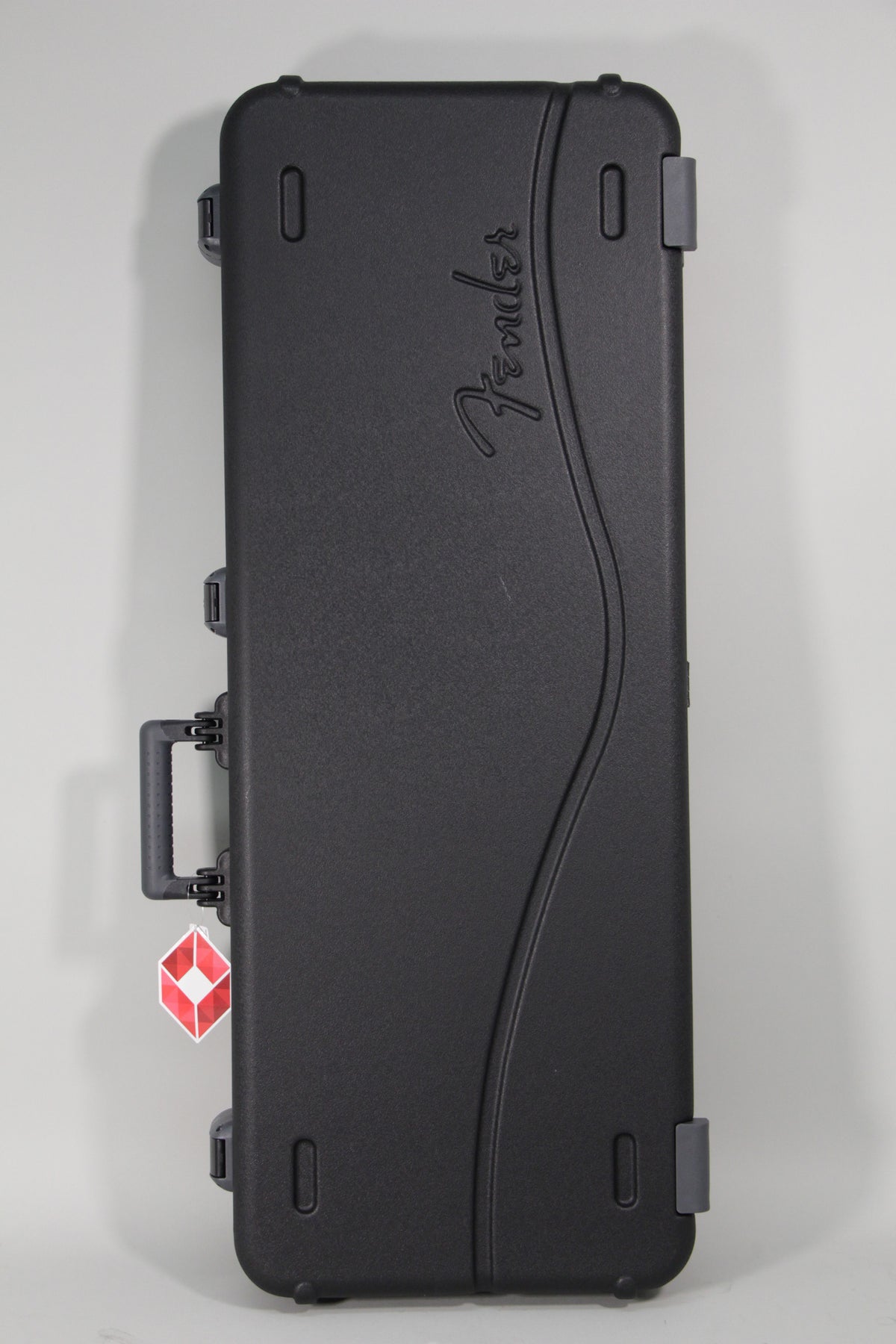 Black hard-shell guitar case with a textured finish, showing the top and side, with a TSA lock tag on the handle.