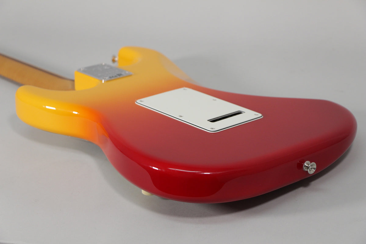 The guitar's glossy Tequila Sunrise back, fading from yellow to red, shows a white tremolo cover and chrome strap button.